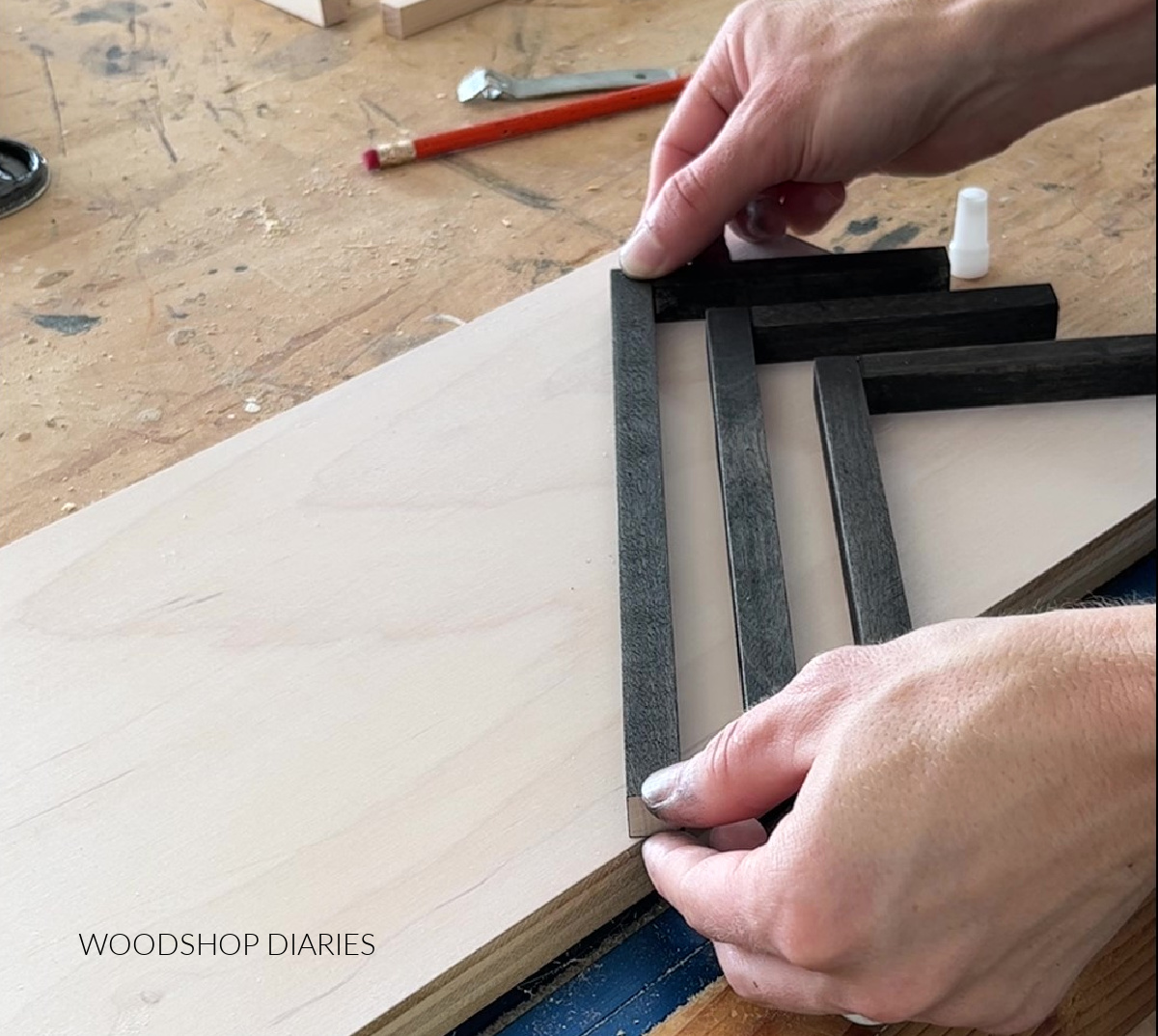 Gluing stained dowels in chevron pattern on wooden art back panel