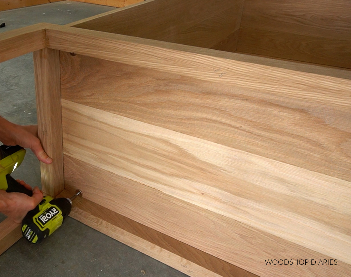 Shara Woodshop Diaries screwing brackets on base to cabinet bottom