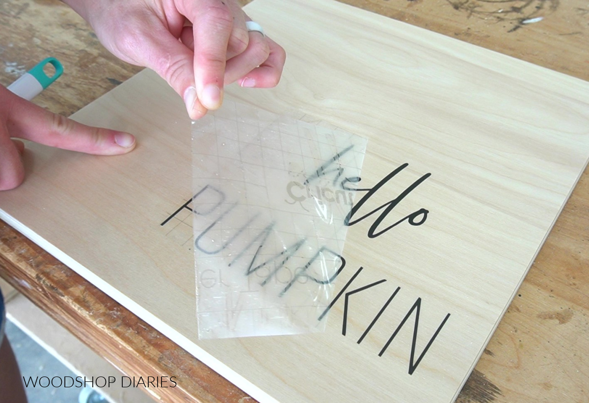 Removing transfer tape from vinyl hello pumpkin wood art lettering on plywood