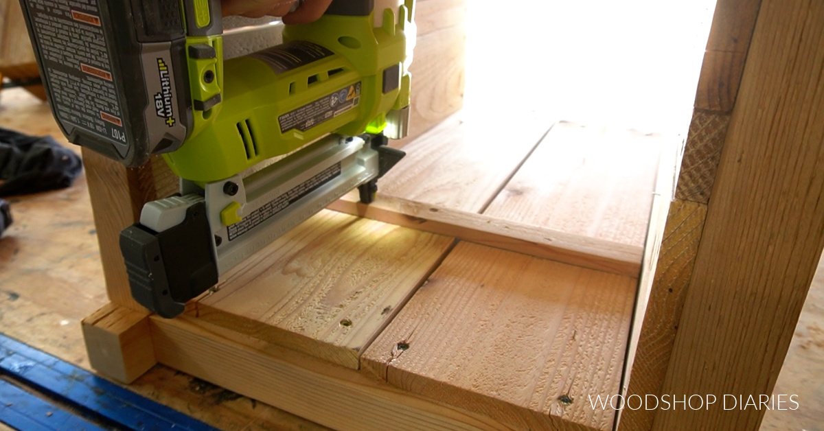 Using a nailer to secure shelf supports on inside of wooden planters