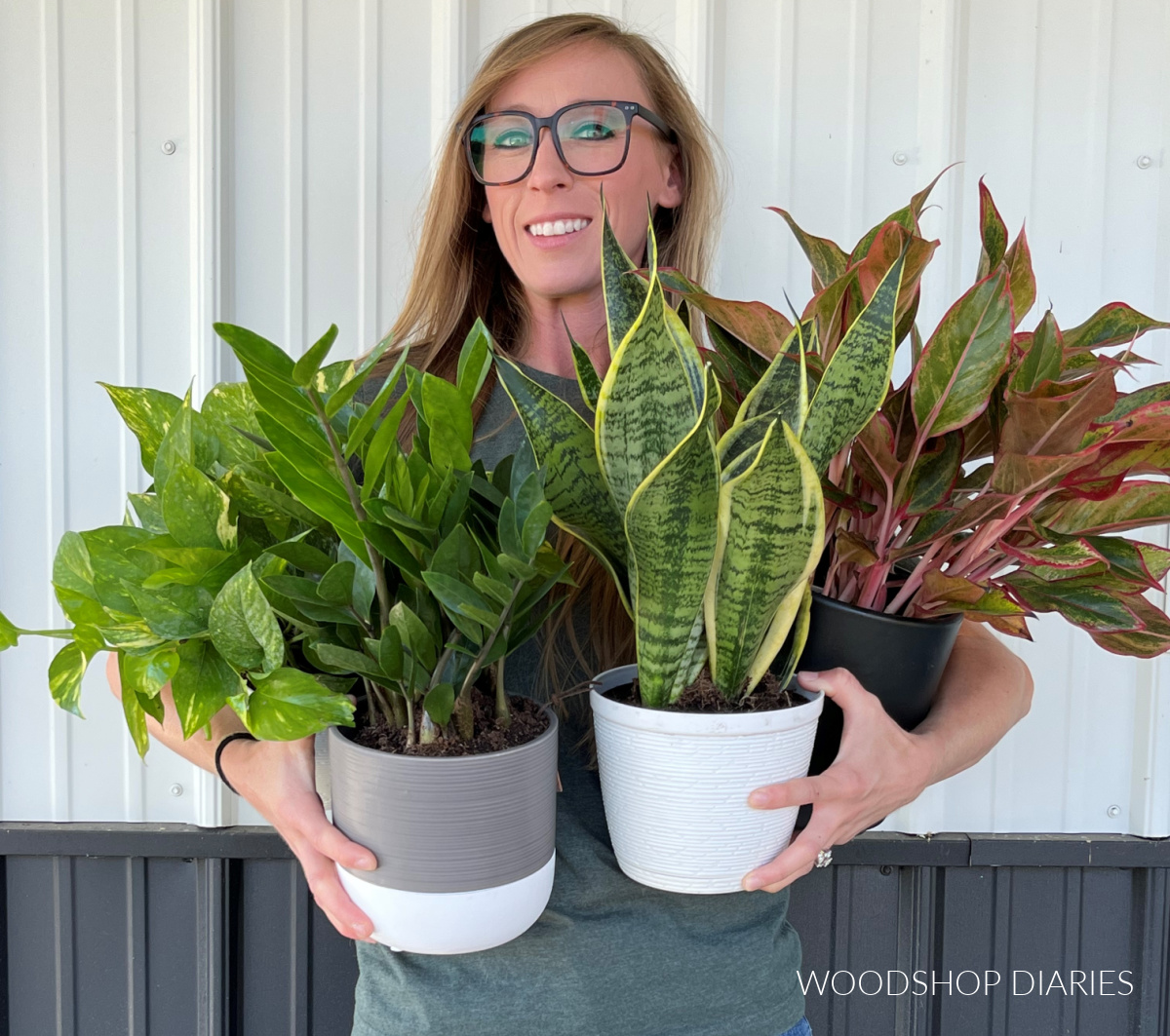 Shara Woodshop Diaries holding various plants in her arms