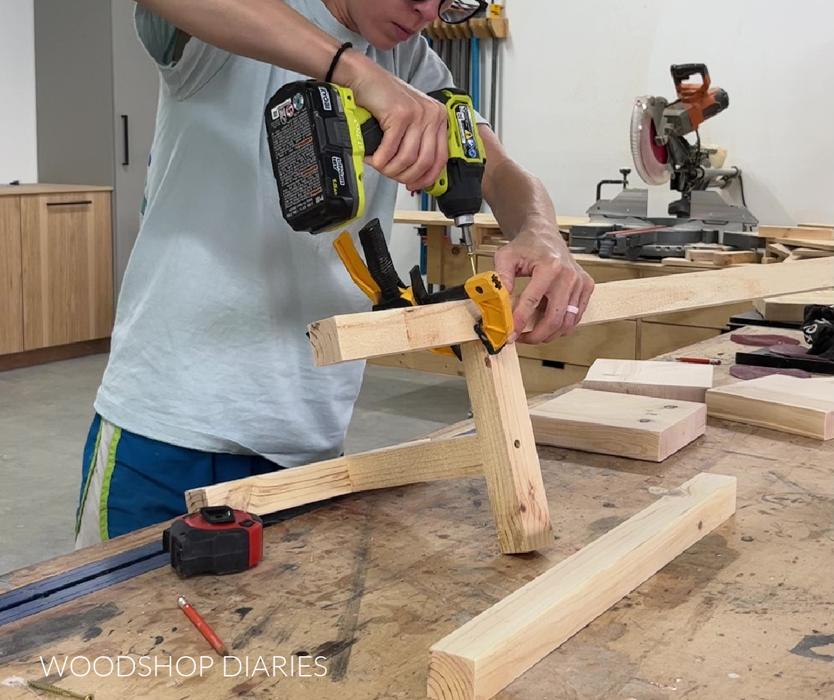 Shara Woodshop Diaries screwing plant stand tiers to T brace on workbench 