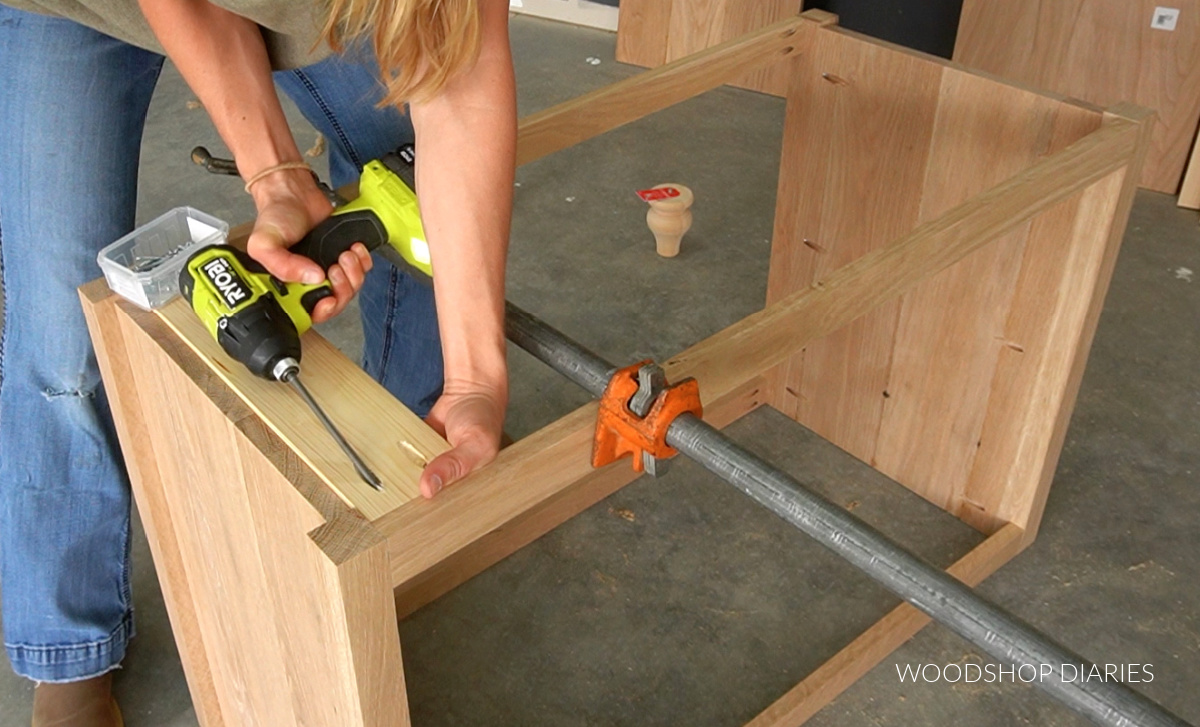 Shara Woodshop Diaries installing scrap block on bottom of dresser using pocket holes