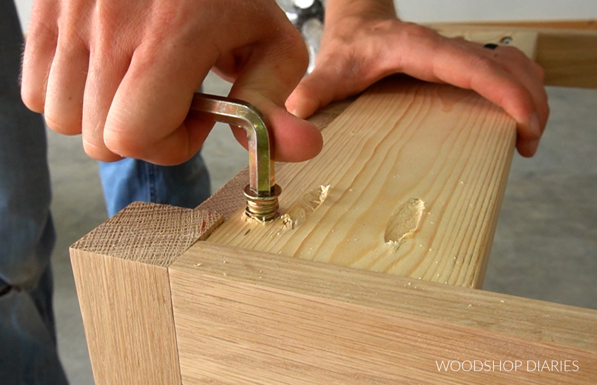 Using hex wrench to screw in threaded inserts in scrap wood block