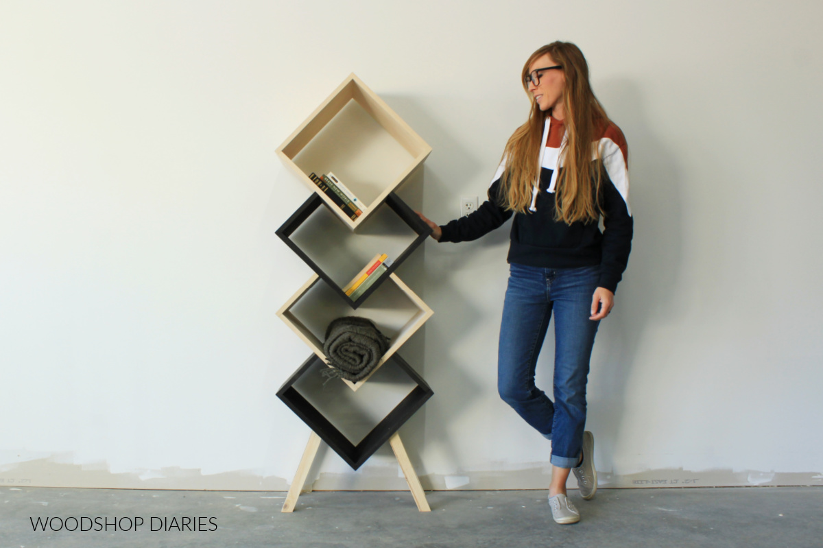 Shara Woodshop Diaries standing next to two tone modern DIY wooden geometric bookshelf
