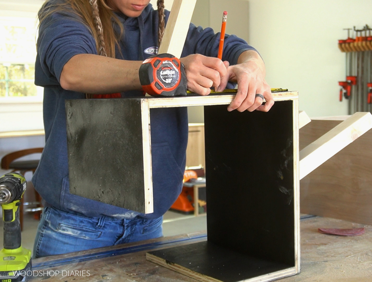 Shara Woodshop Diaries Measuring and marking where legs attach to bottom shelf box