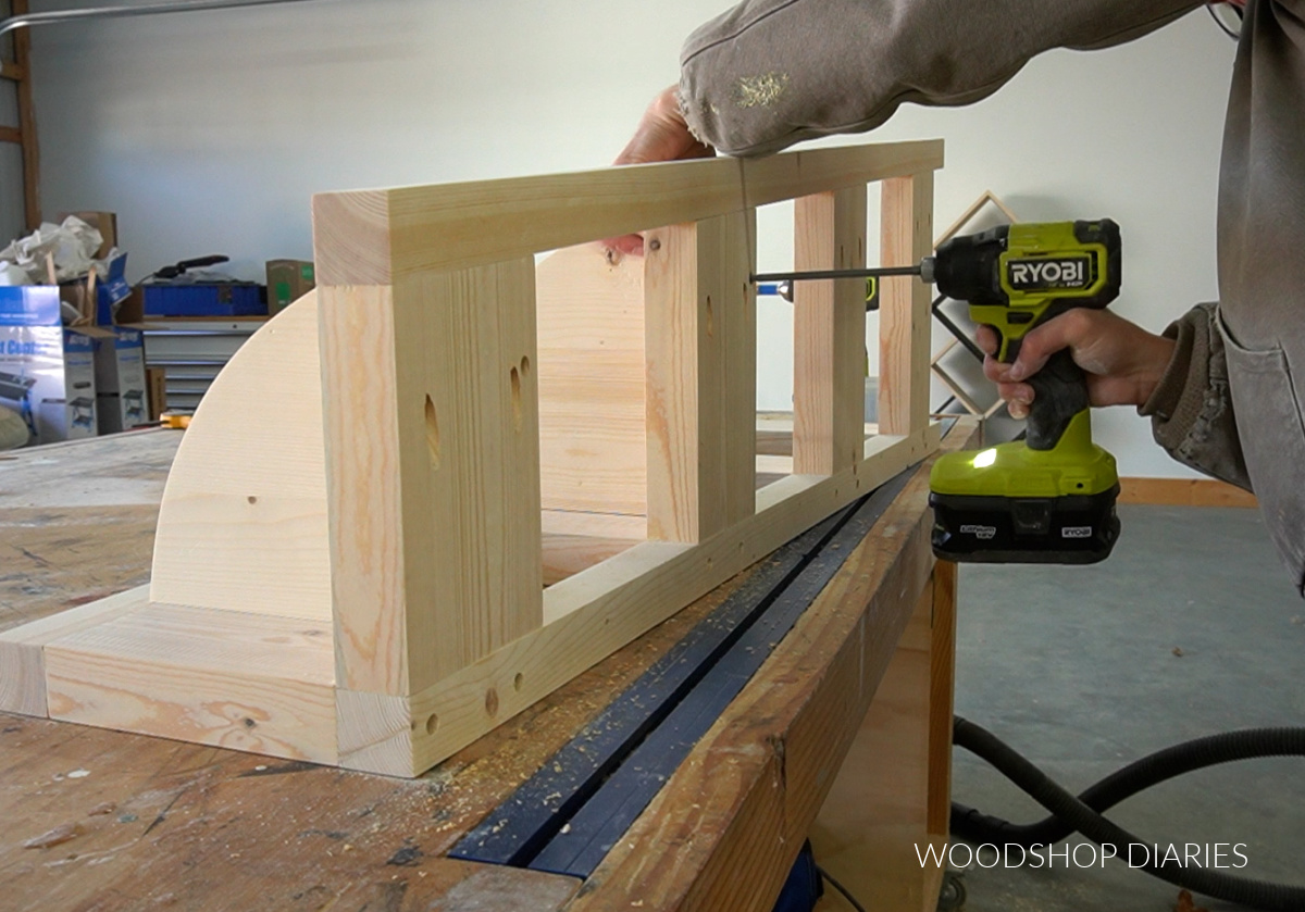 Using a Ryobi driver to install corner shelves into frame on back side