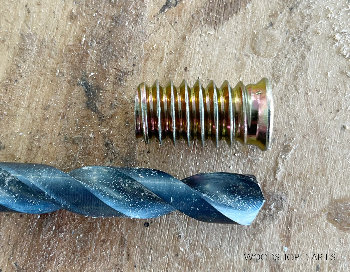 Drill bit laying on workbench next to threaded insert