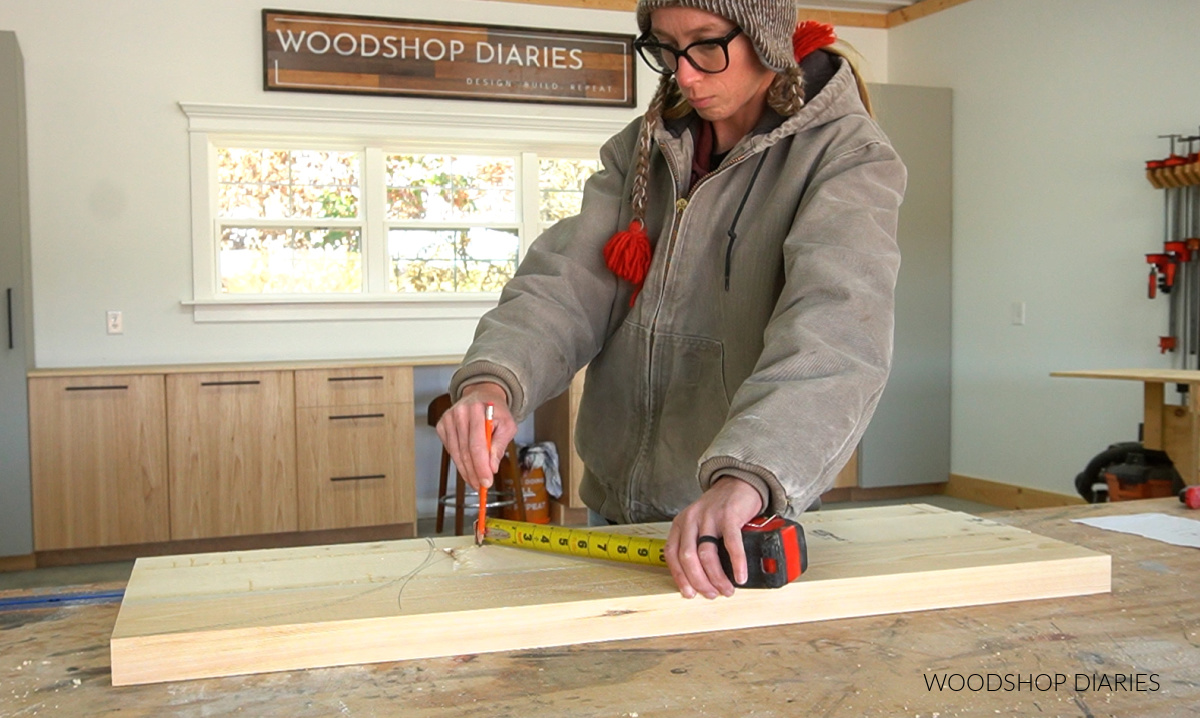 Shara Woodshop Diaries using tape measure to draw arches on wood panel on workbench