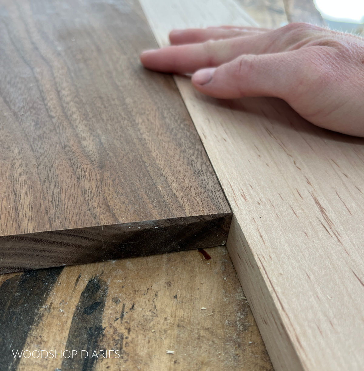 Maple and walnut boards laying side by side on workbench showing they're the same thickness