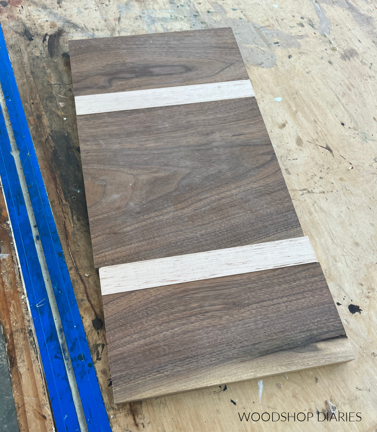 DIY walnut and maple cutting board pieces dry fit and laid out on workbench