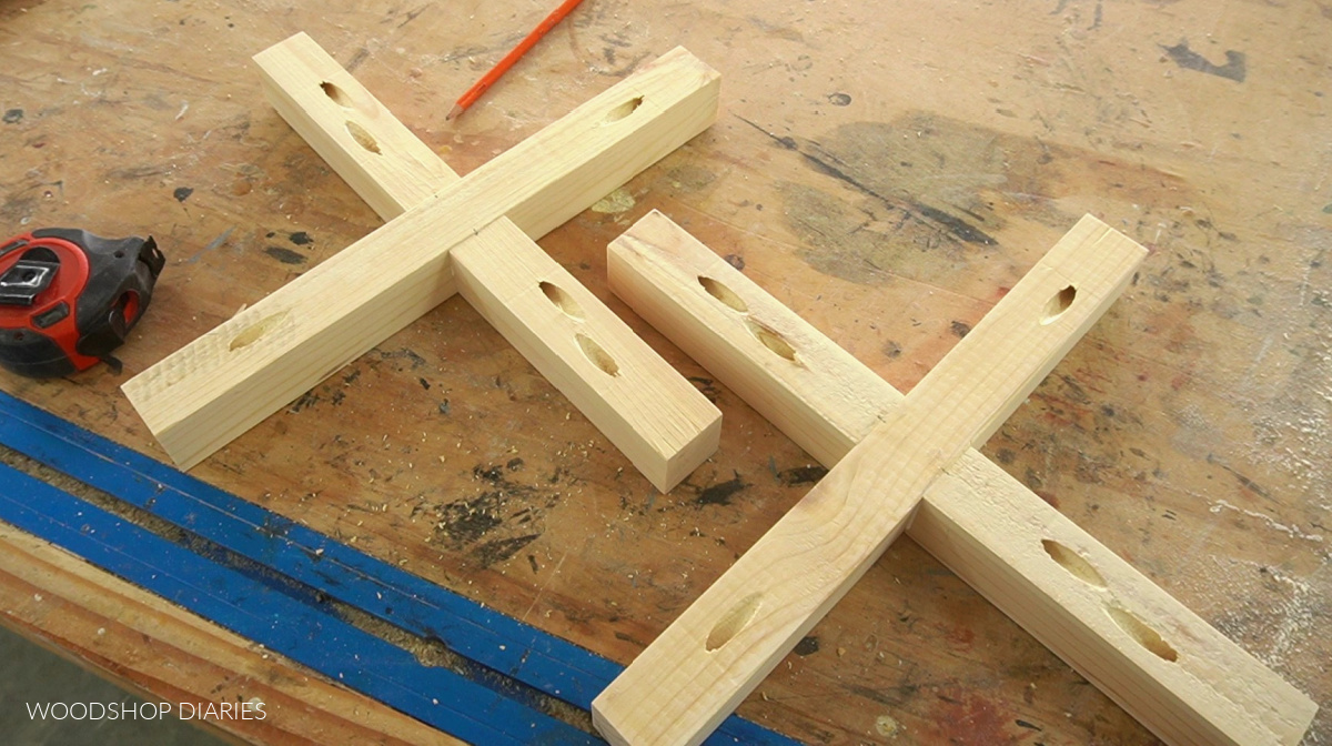 X braces with pocket holes drilled and assembled laying out on workbench surface
