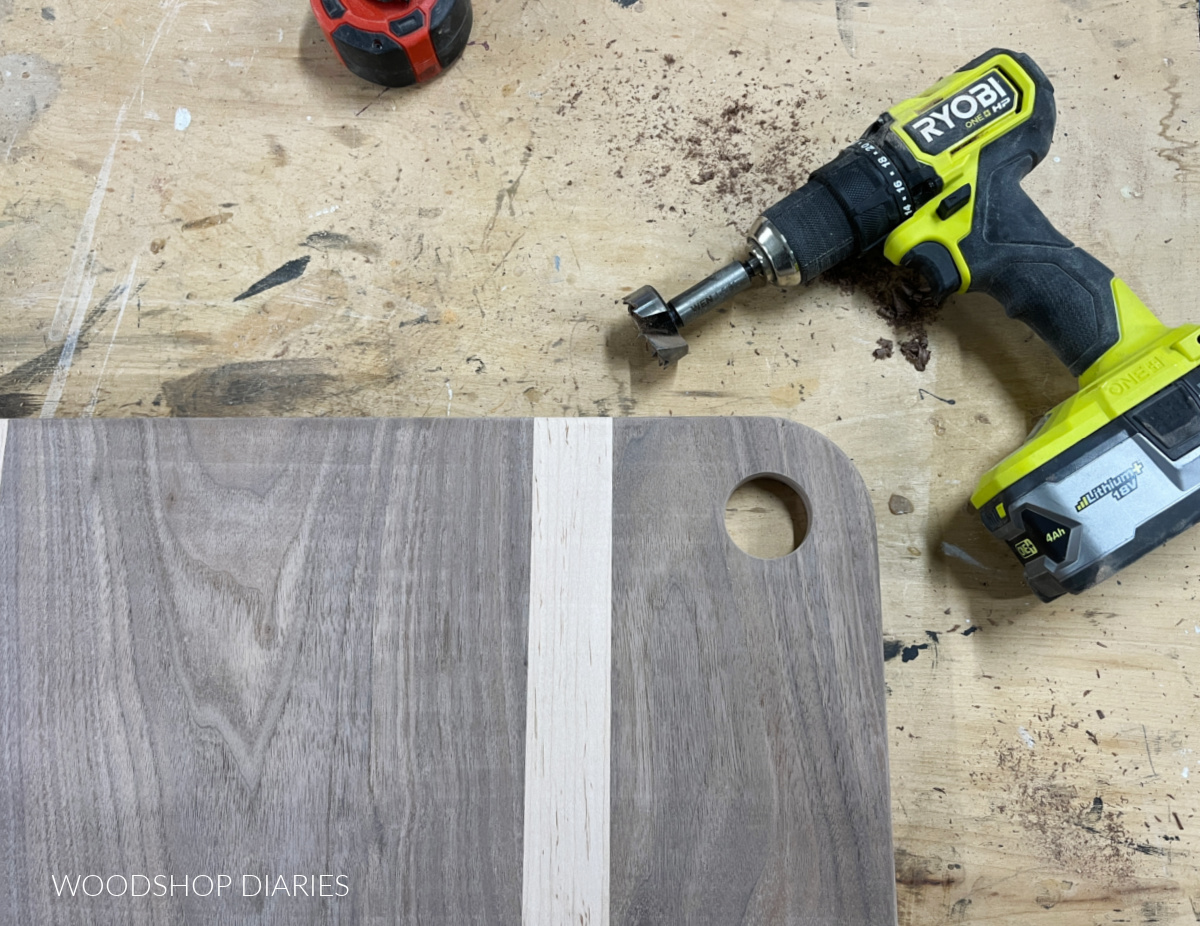 maple and walnut cutting board with curved corner and a hole drilled out