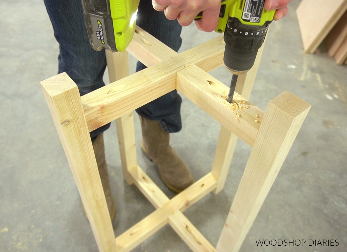 Close up of drilling oversized holes to install top and bottom of plant stand