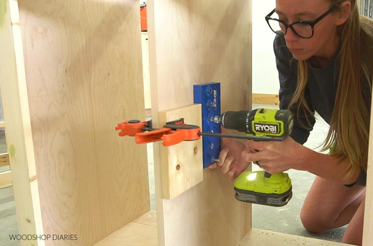 Shara Woodshop Diaries drilling shelf pin holes into cabinet sections using Kreg shelf pin jig