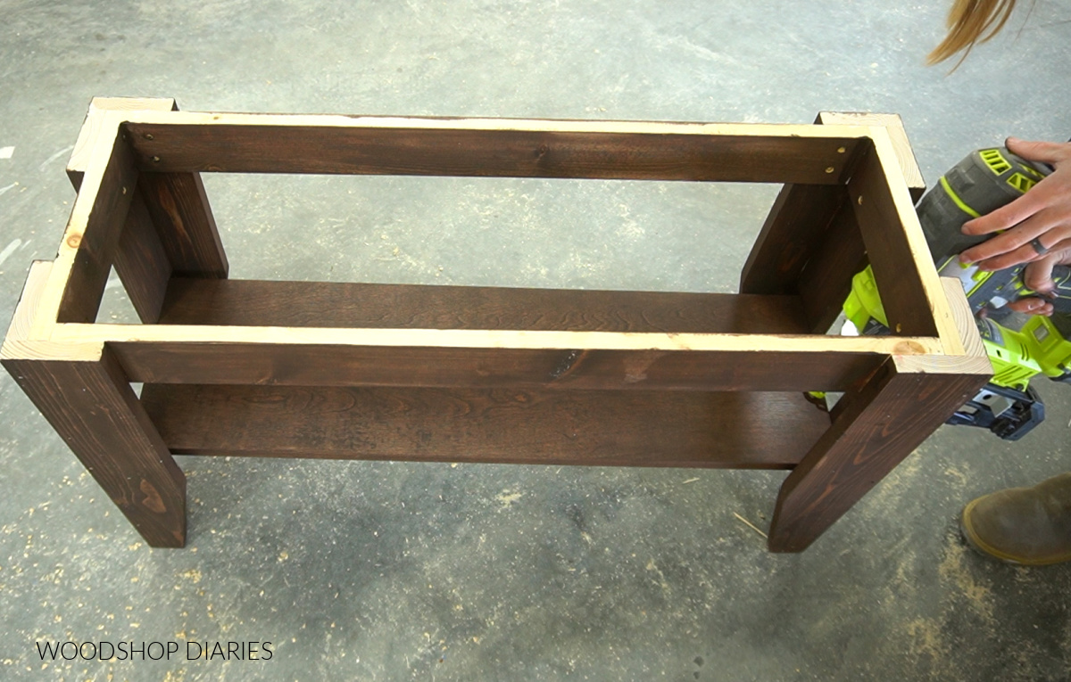 Using a finish nailer to secure shoe shelf into bench frame