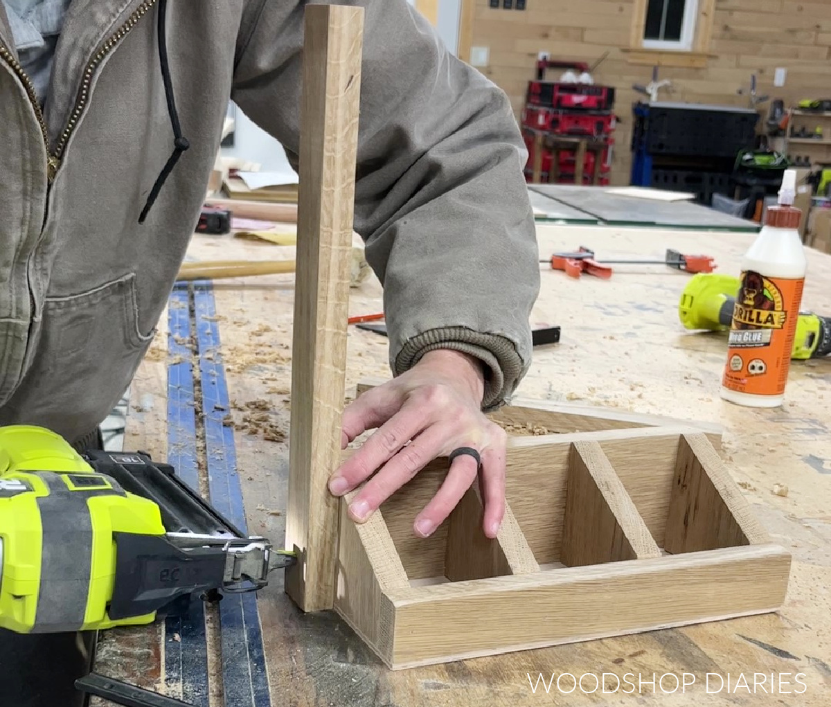 Shara Woodshop Diaries using brad nailer to secure 1x2s to side of tea box storage organizer