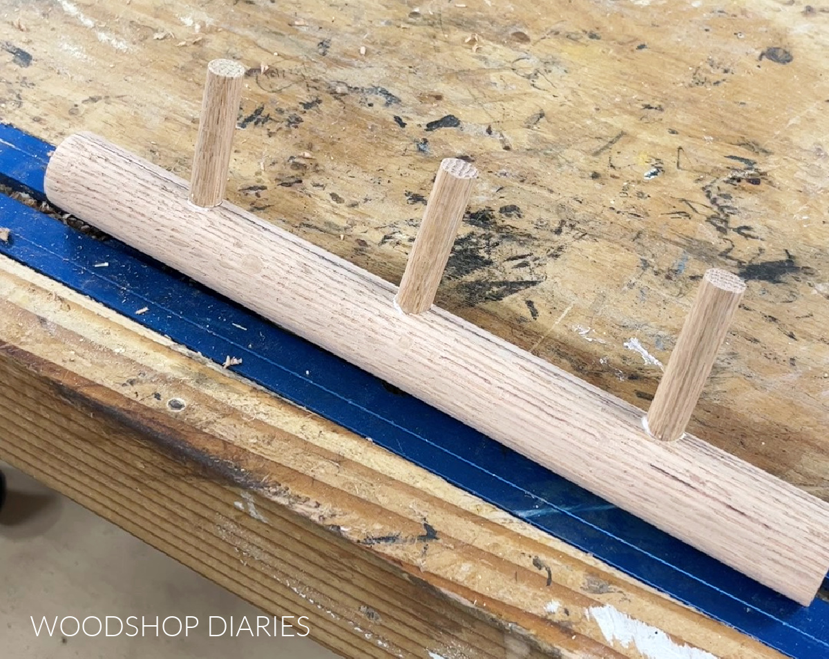 smaller pegs glued into holes drilled in larger dowel