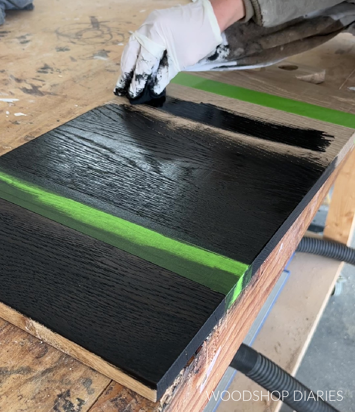 applying black stain to white oak wooden serving board