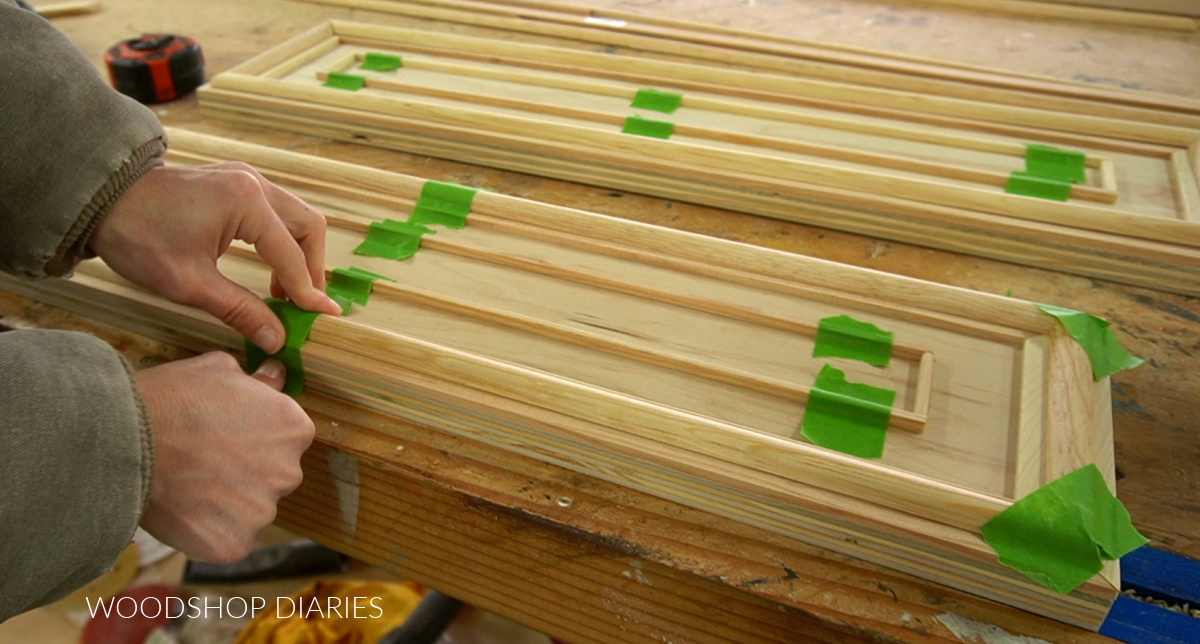 Shara Woodshop Diaries taping half round molding onto drawer fronts while glue dries