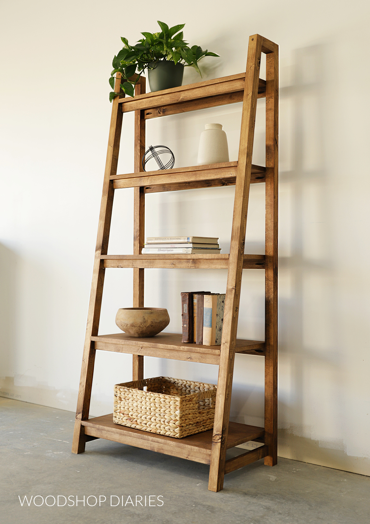 Completed 5 tier wooden DIY ladder bookshelf with decor on each tier