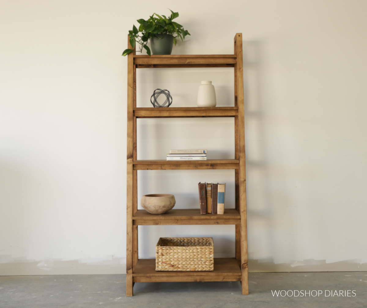 Front view of freestanding ladder style bookshelf with books and decor 