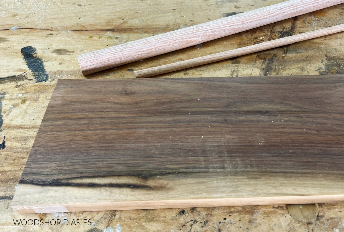 Walnut board and red oak dowels lying on work surface--materials for key holder tray