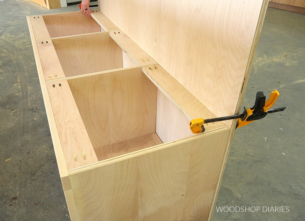 Large ¾" plywood back panel clamped onto storage bench frame