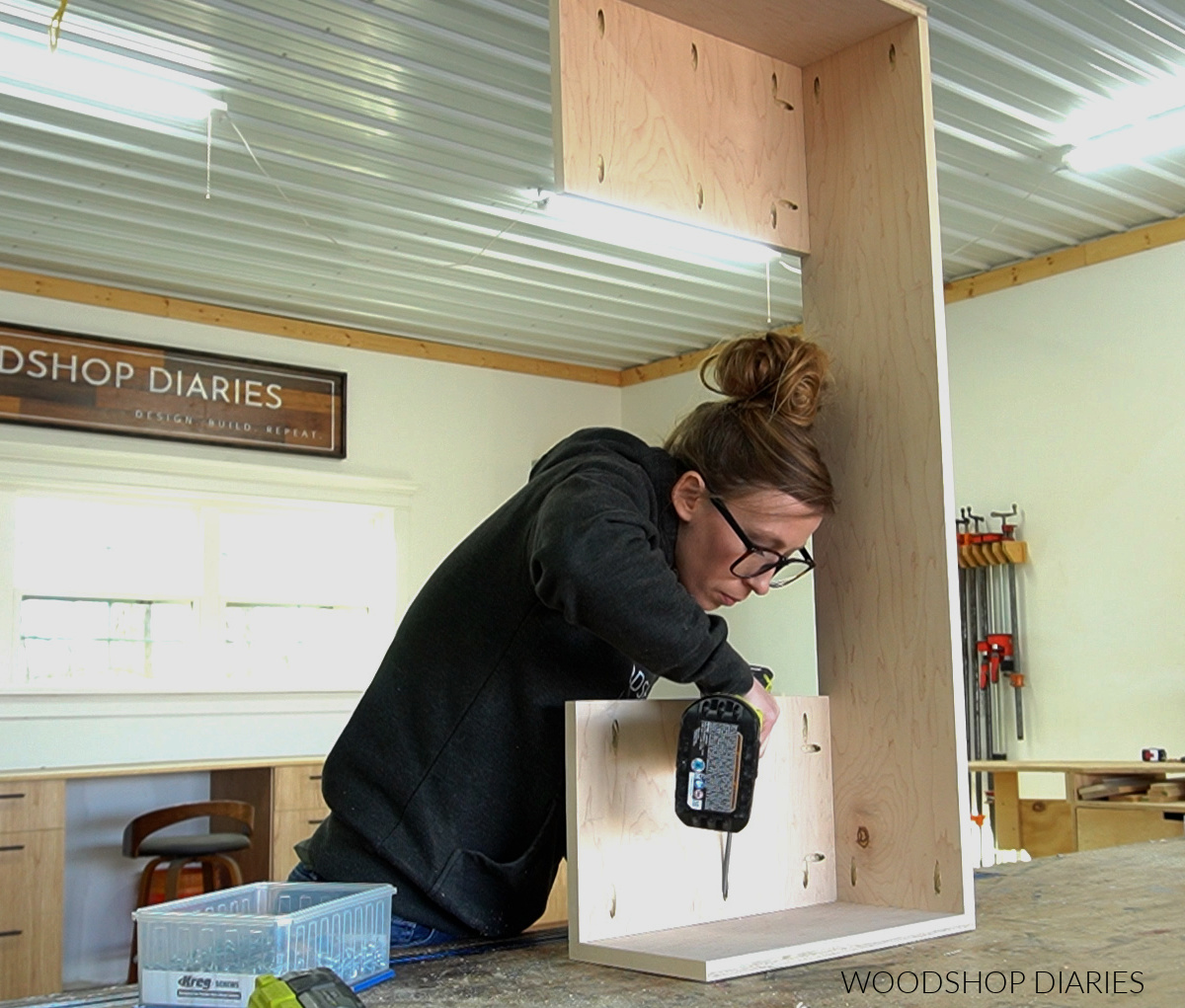 Shara Woodshop Diaries installing bottom panels into DIY vanity desk frame using pocket holes