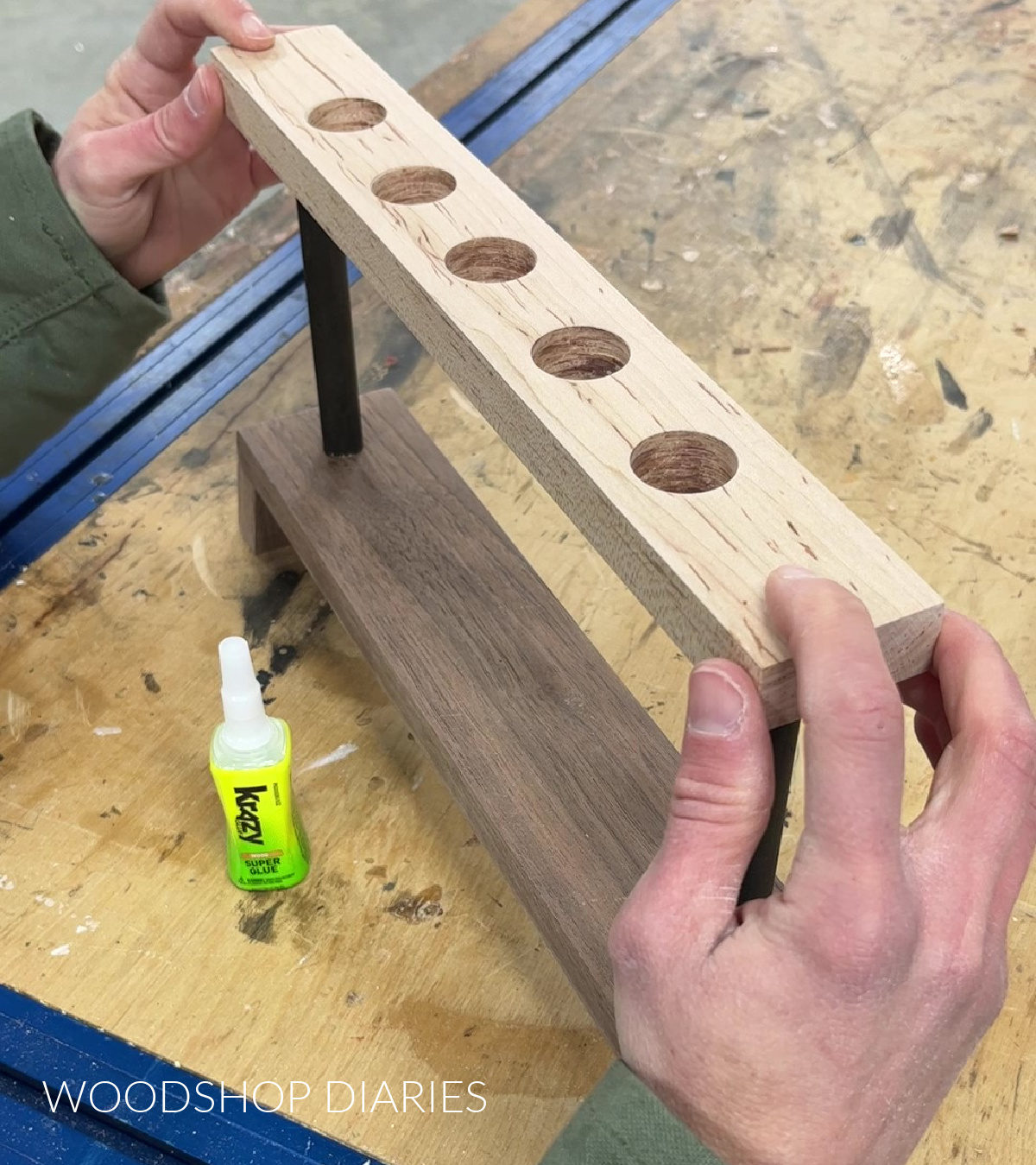 holding top of wooden test tube station on dowels while glue dries