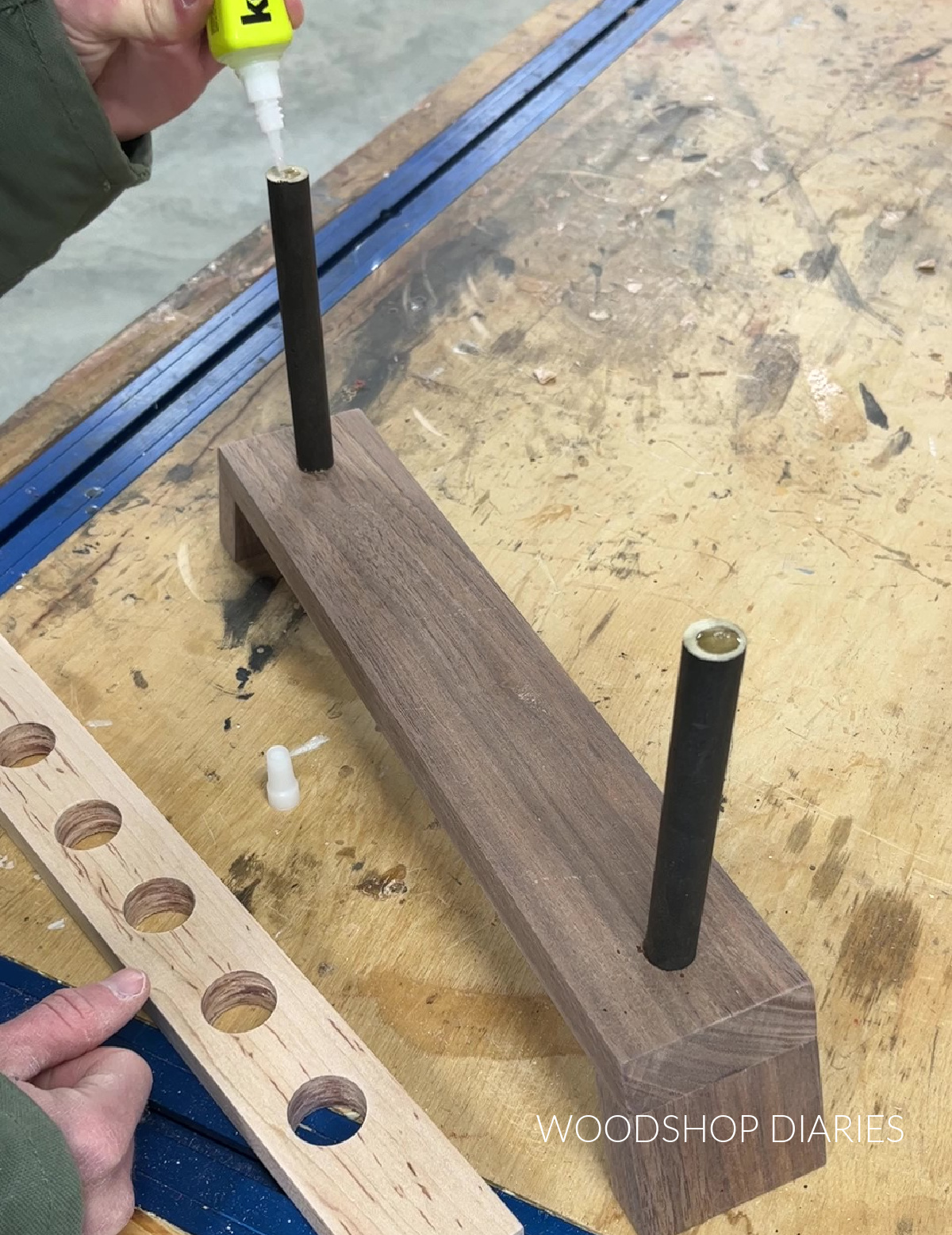 Applying wood glue to top of wood dowels