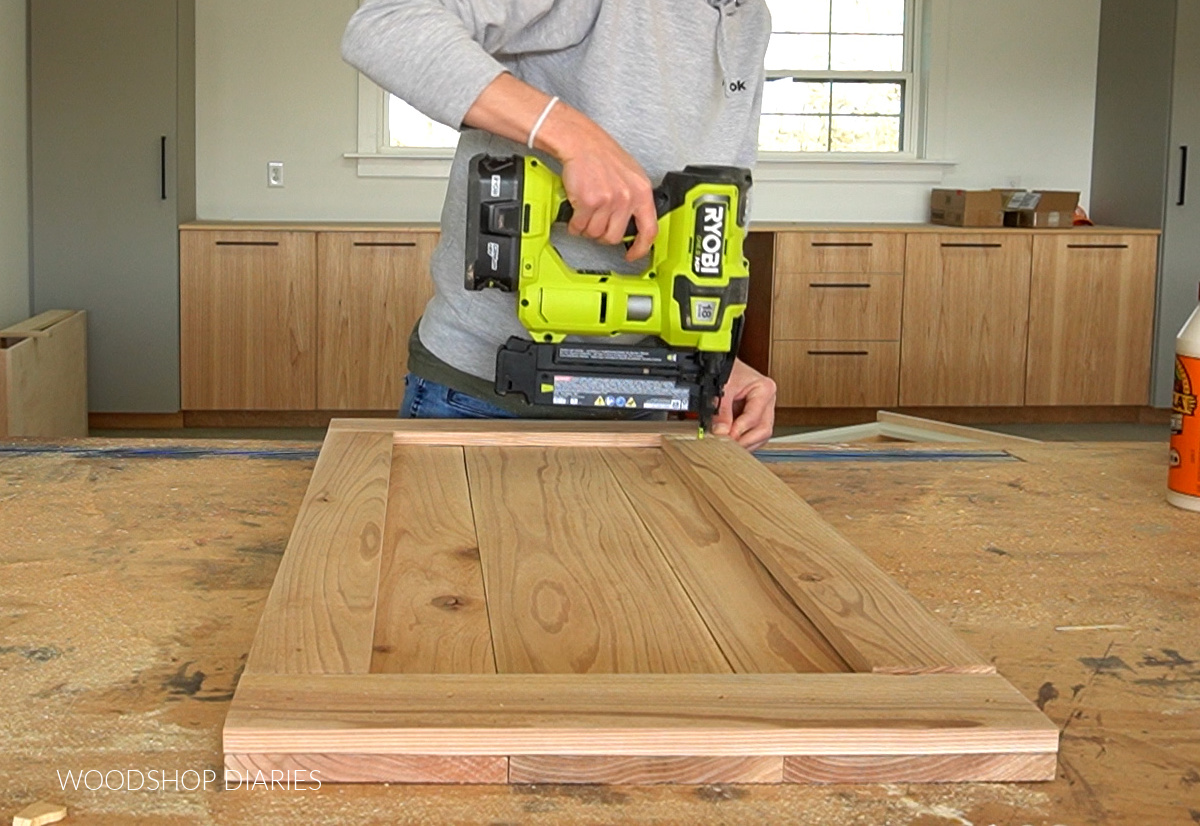 Brad nailer securing boards onto sliding barn door 