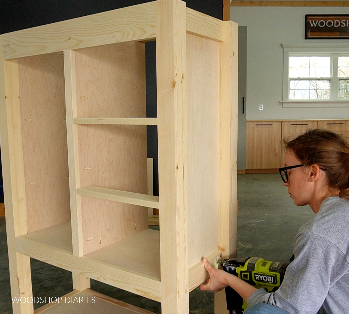 Shara Woodshop Diaries nailing 1x3s on sides of cabinet