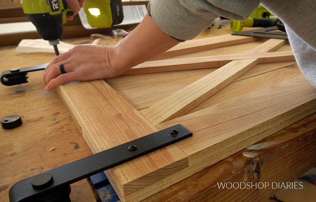 using a drill to secure sliding door roller hardware onto door