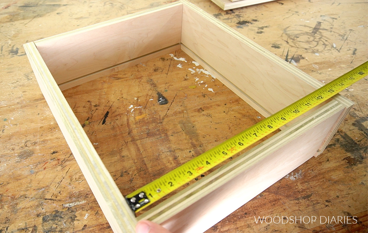 Drawer box sides dry fit together on workbench with tape measure measuring inside dimensions