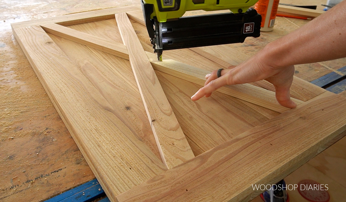 Using a brad nailer to secure X trim on barn door