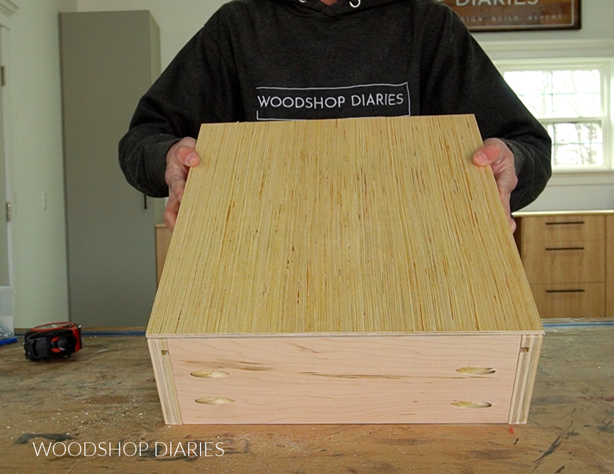 Drawer box assembled and shown upside down with plywood bottom panel placed on top
