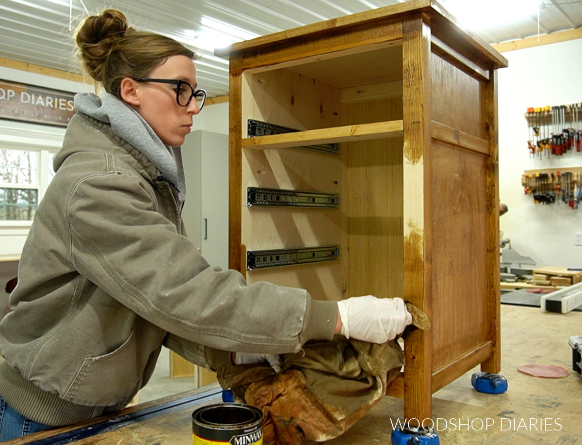 Shara Woodshop Diaries applying wood stain to frame of cabinet