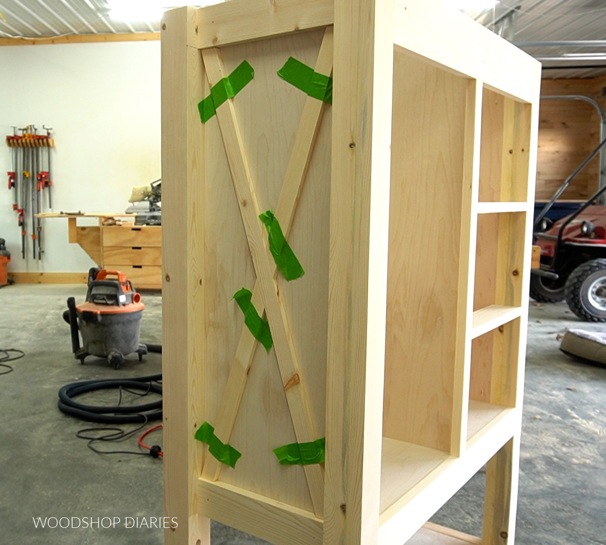 painters tape used to hold X trim pieces in place on side of dresser cabinet