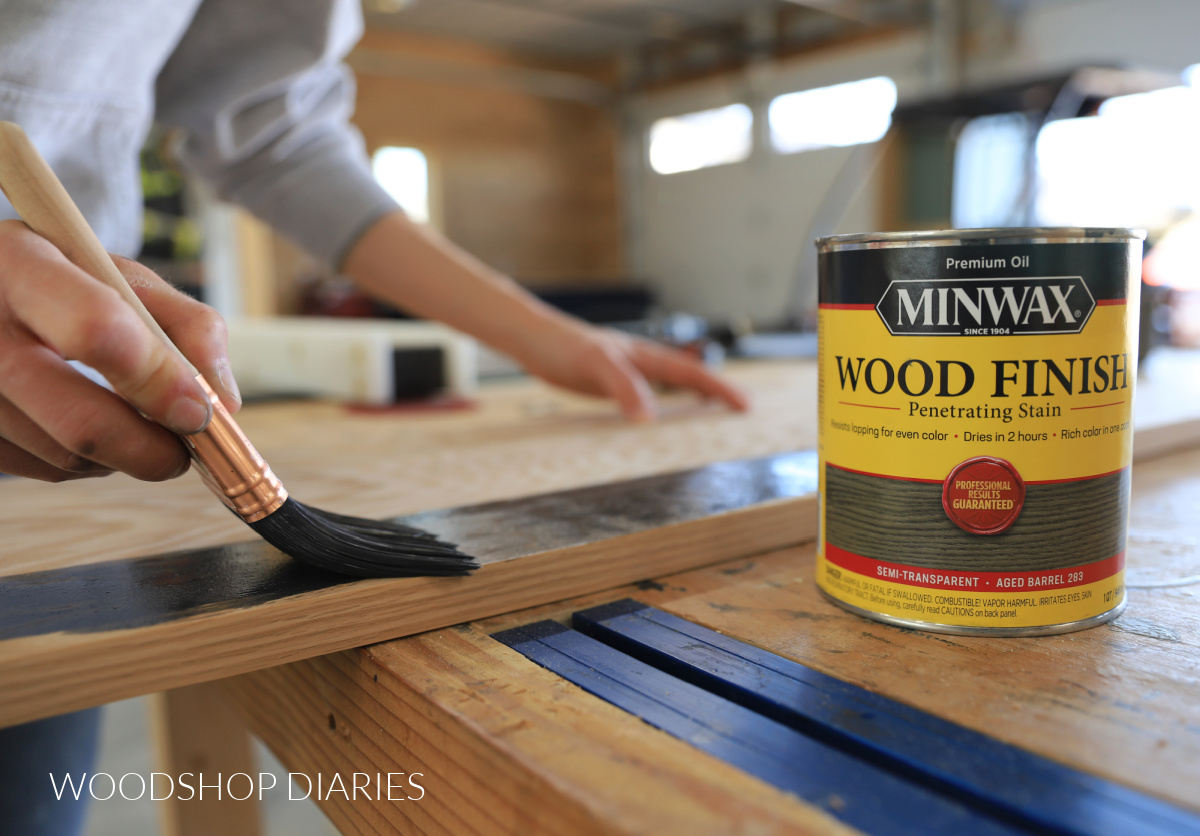 Close up of applying oil based stain to oak plywood with a brush