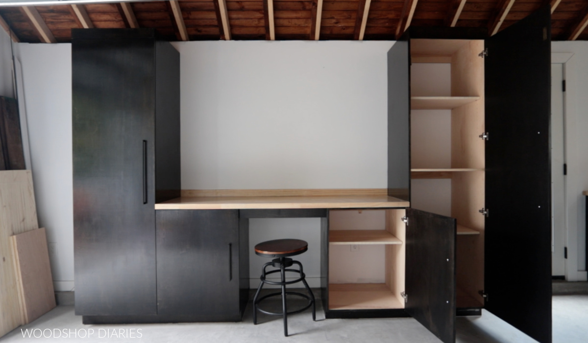 Black workshop cabinets with butcherblock top with right two cabinet doors opened showing adjustable shelves inside