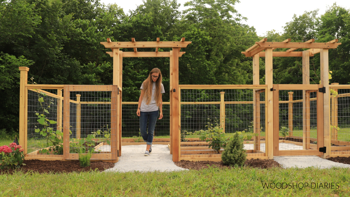 Shara Woodshop Diaries walking in enclosed garden under arbor with gate open