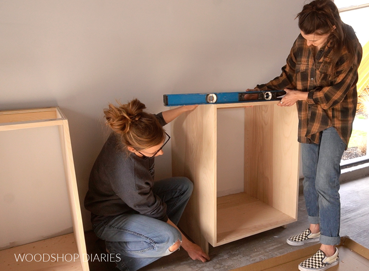 Shara and Sam leveling garage base cabinet with shims