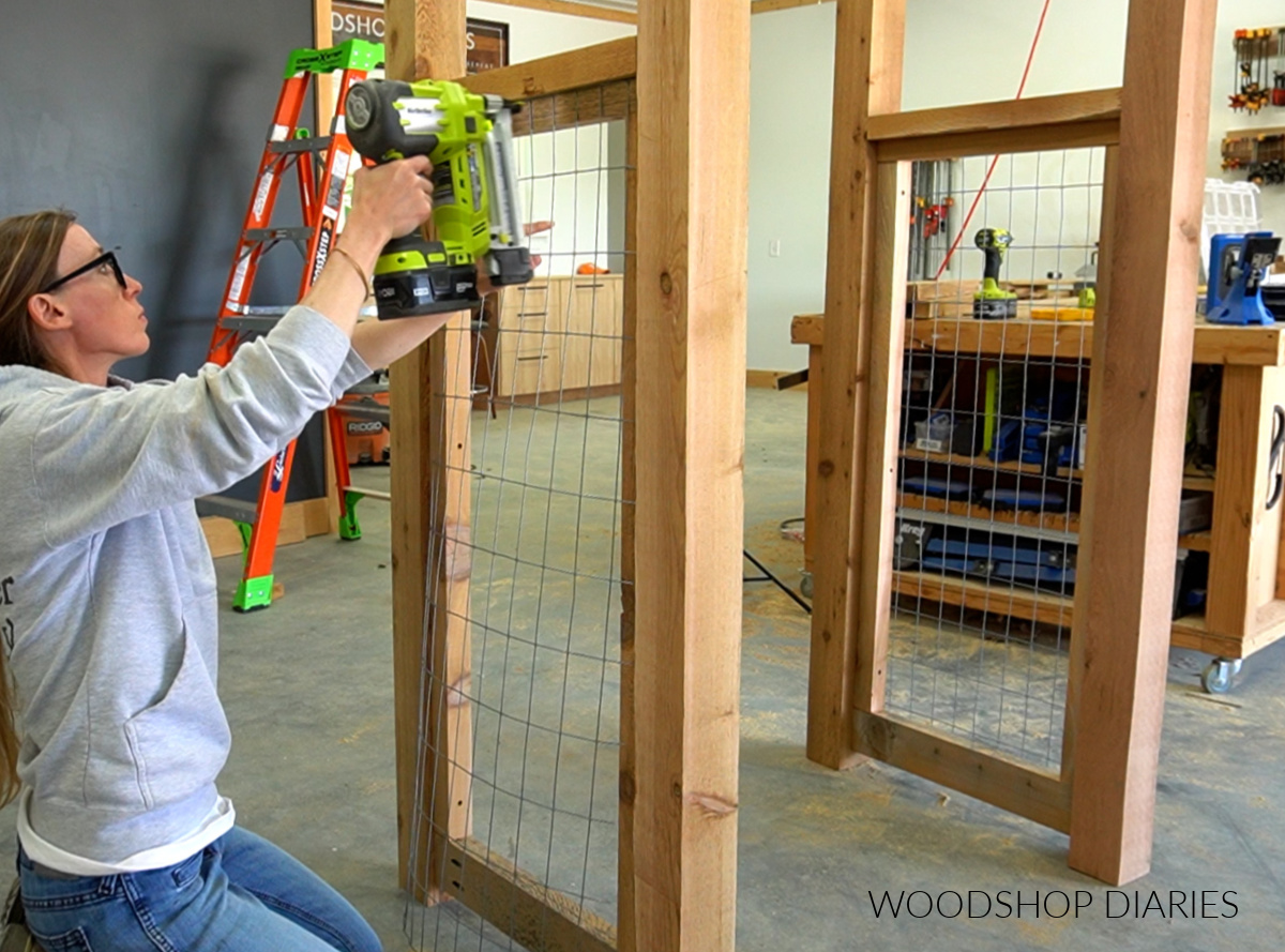 Shara Woodshop Diaries stapling welded wire fence panels onto sides of arbor framing 
