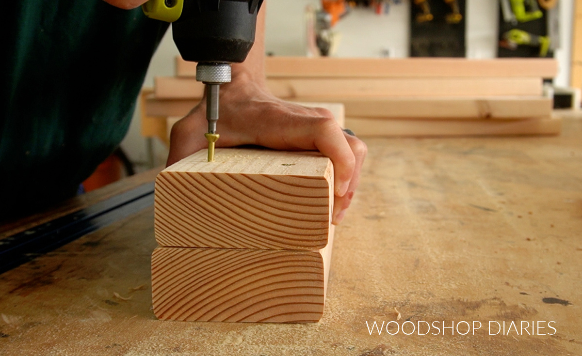 Close up of driving screw through 2x4s to create workbench legs