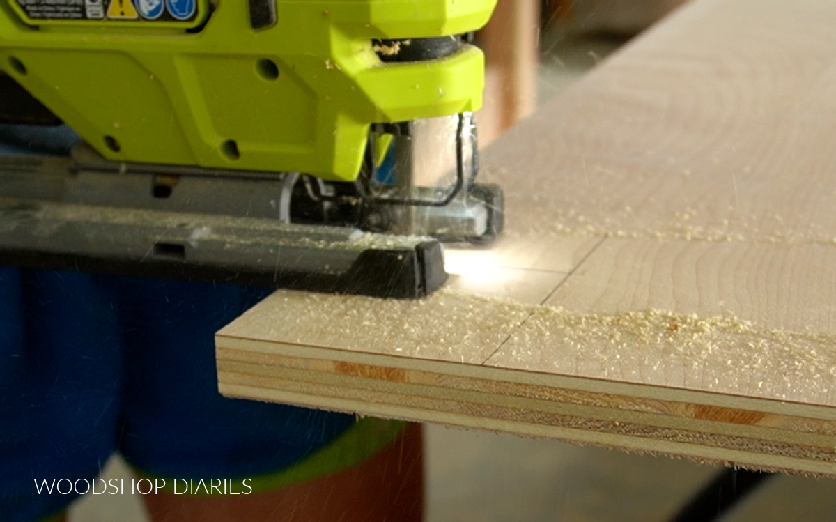 Close up of jig saw cutting corner out of plywood panel