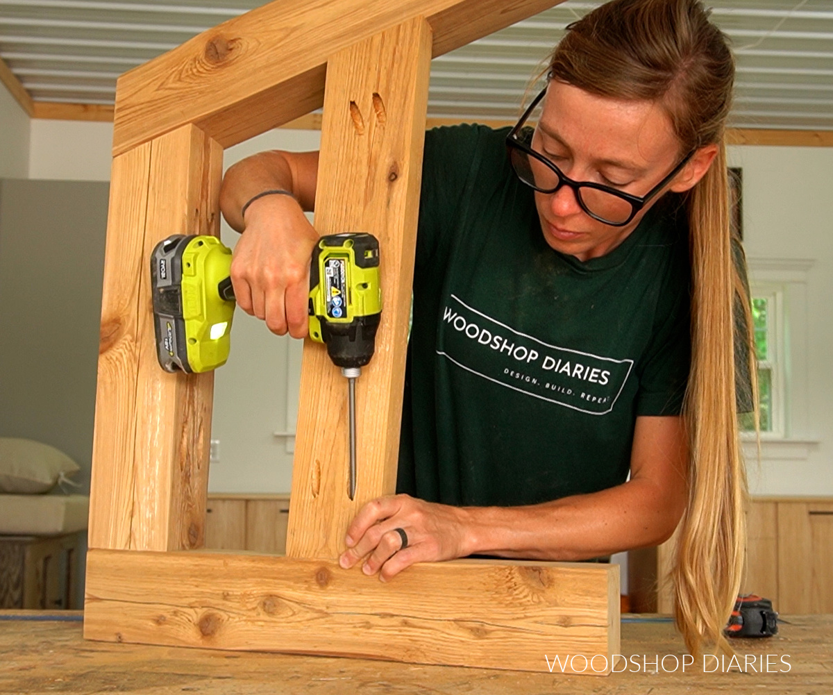 Shara Woodshop Diaries securing 2x4 seat slat on outdoor sofa side frame with pocket holes on workbench