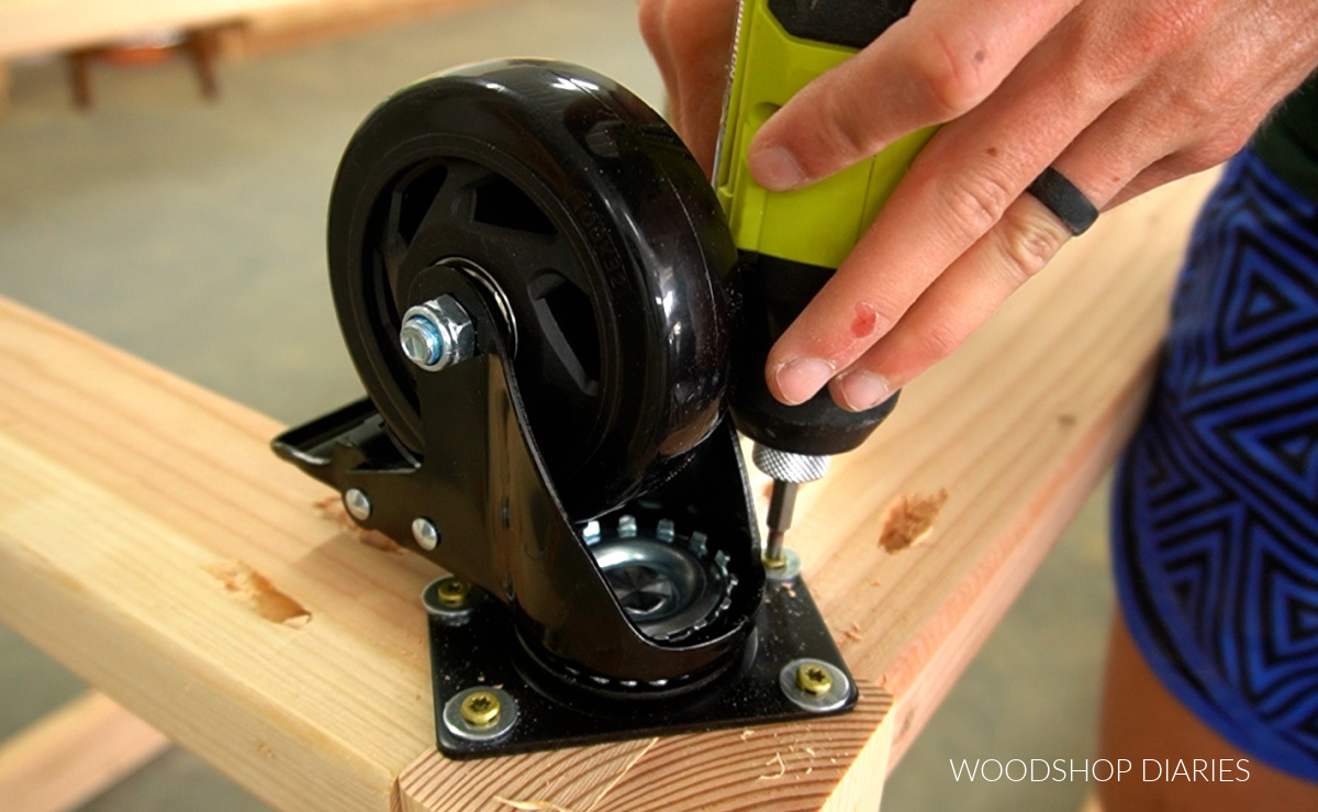 Close up driving screws to install caster wheels on workbench corners
