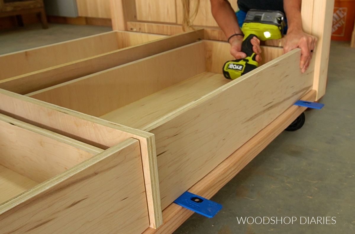 Driving screws through front of drawer box to attach drawer fronts in workbench