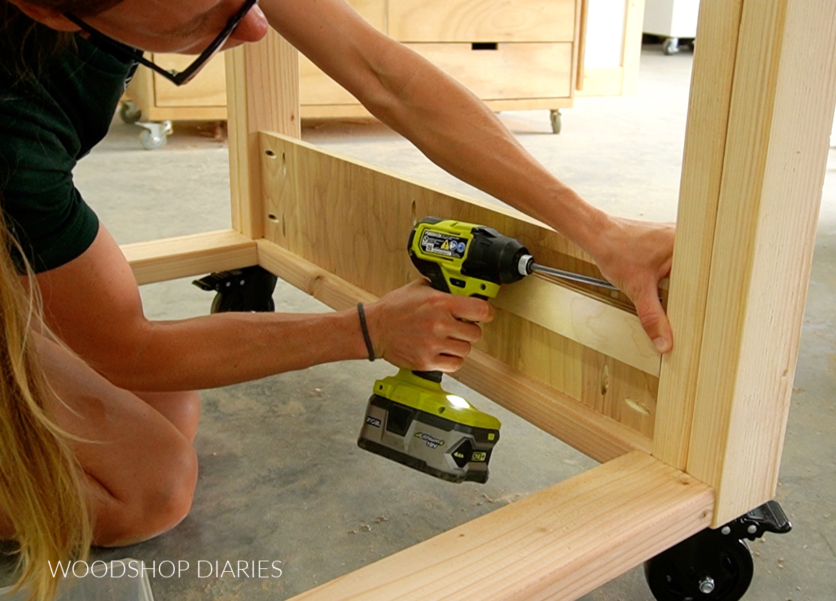 Using pocket holes to secure side panels into workbench between corner posts